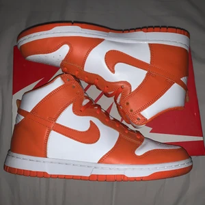 NIKE DUNK ”SYRACUSE” HI RETRO  - Inköpta i maj hos hypestein för 2300kr, använda 2-3 gånger. No Creasing, inga synliga defekter förutom på sulan men där syns det bara att de blivit använda men inga större skador. Mindre i storleken än vad man tror, jag har vanligtvis 40/41 men dessa är på gränsen att de inte passar. Supersnygga om man stylar de rätt. Inte intresserad av byten.