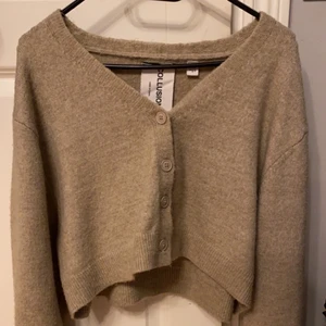 Croppad kofta storlek M. Oanvänd  - Oanvänd croppad kardigan i sandfärg. Oanvänd. Storlek M