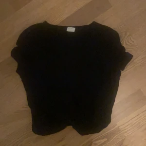 Svart topp med skärning i fram  - Svart topp med skärning i fram från Gina tricot i storlek S