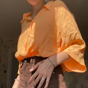 Weekday orange skjorta stl L - En sjukt skön och luftig skjorta från weekday som aldrig blivit använd av mig. Passformen är bred och ärmarna går ner till armvecken. Kan knytas eller stoppas in i byxorna samt tunn i tyget och lätt att styla. Som referens är jag 173 cm lång och har S i stl:)))