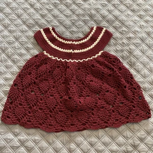 Virkad baby klänning - Denna har jag gjort själv.  Den passar barn i 3-6 månader.   Den är 36 cm lång( från axeln till kanten på kläningen)  Och är 51 cm bred.   Den tvättas i 30 grader  Garnet är av bomull.  Köparen står för frakten. Finns i ett rök och djurfritt hem