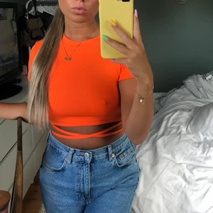 Söt topp - Aldrig använd denna oranga topp från bershka. Fin snörning som går runt midjan och öppen rygg. Väldigt stretchig i materialet.