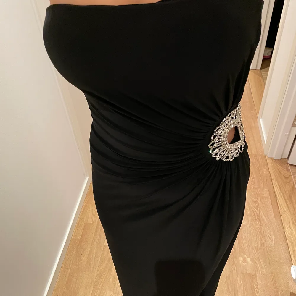 Säljer denna svarta klänning med en fin silver detalj. Köpt i en butik i London, Monsoon. Klänningen passar Xs/S . Klänningar.