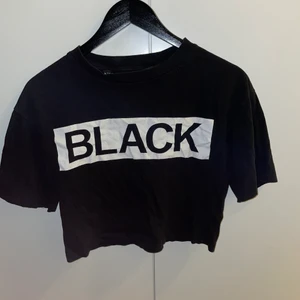 BLACK crop top - Svart crop top med ett vita tryckta bokstäver ”BLACK”, i storlek S men passas även som XS. Sitter väldigt skönt och slappt på kroppen!