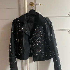 Skinnjacka - Säljer denna as balla skinn jackan med nitar,hjärtan och stjärnor på🧡🧡😍😍 Den är i super bra skick men vet dock tyvärr inte vart den kommer ifrån då det inte är ngn lapp på och jag köpte den för länge sen!! Den är i storlek M men passar mig som är XS då jag tycker det är coolt när den är lite mer oversized, skulle säga att den är lite croppad för att vara M men den slutar precis över rumpan💛 köp direkt för 500+ frakt eller buda❤️