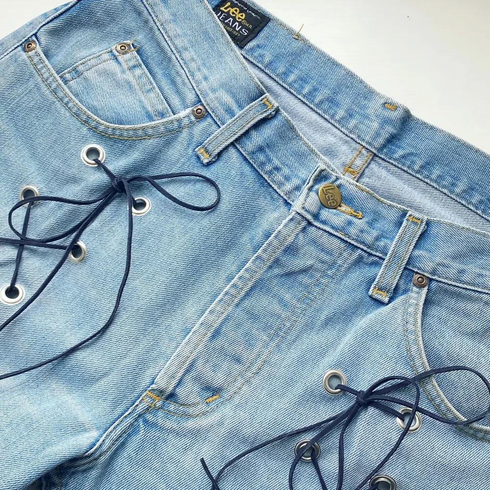 Lee secondhand-jeans med mörkblå snörning. Designade av Ezzie i samarbete med Ebba Martin. (Shipping only within Sweden). Jeans & Byxor.