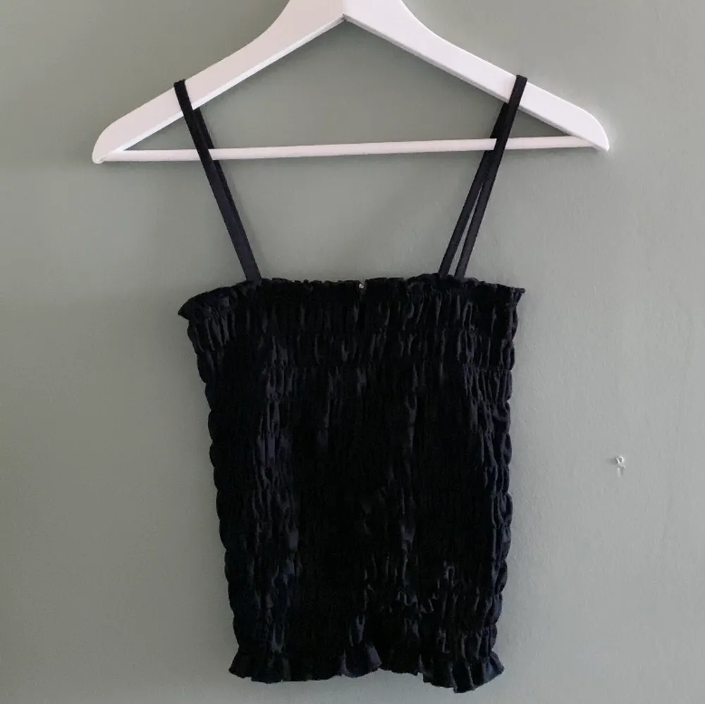Ett svart linne som är sytt för att få ett ”scrunchigt” utseende. Använt en gång och är köpt på BikBok.. Toppar.