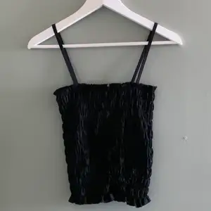 Ett svart linne som är sytt för att få ett ”scrunchigt” utseende. Använt en gång och är köpt på BikBok.