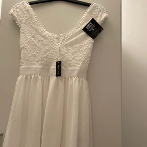 Vit klänning från Nelly storlek 34 - Endast provad, lapparna finns kvar. Passar perfekt till sommar/studentklänning