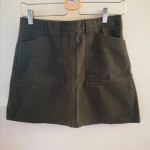 Militärgrön kjol från UO - Kort militärgrön kjol med dragkedja där bak. Köpt på Urban Outfitters för några år sedan. Väldigt sparsamt använd. 