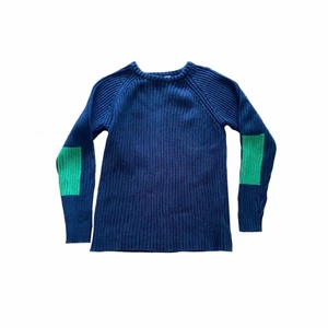 Stickad tröja Stella McCartney  - En mörkblå stickad bomullströja med gröna detaljer på baksidan av armbågarna från Stella McCartney kids. Passar en XS-S. Väl använd med i bra skick! (Den är i barnstorlek 12 men passar en XS-S) 