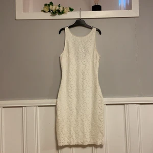 Vit figursydd spetsklänning stl s - Väldigt fin spetsklänning i fint skick! Figursydd. Hög urringning fram och lägre skuren i bak. Osynlig dragkedja i sidan. 
