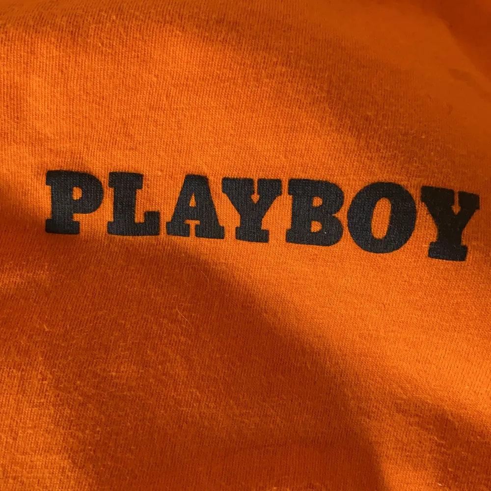 En orange T-shirt med märket Playboy som knappt är använd  och inga direkta tecken på användning, skriv för mer info . T-shirts.