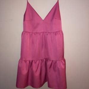 Fin klänning i glansigt rosa material. Storlek 42 men passar mer som en 40