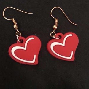 Örhängen  - Ett par fina örhängen i röd och vit.Formen är ett hjärta 💖 