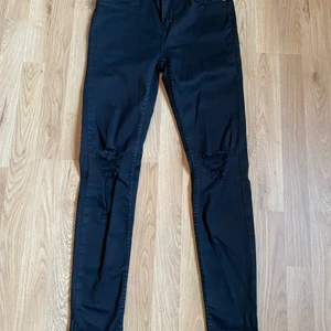 Jeans - Säljer ett par oanvända svarta jeans med hål i i storlek M ifrån lager 157.