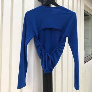 Blå topp. - En blå topp från nelly. Öppen topp med knytning på baksidan. Säljs för 100kr. 