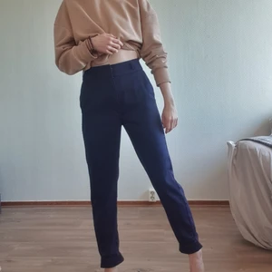 Mörkblå Kostymbyxor  - Mörkblåa kostymbyxor från stradivarius! Från början var dom uppvikta i botten och satt fast så med ett litet stygn som jag sprättat upp för att göra dom lite längre, går nog väldigt lätt att vika upp igen! Jag är 165cm och på mig går dom till fotknölen nu! 