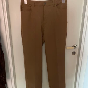 Beiga slacks - Beiga slacks/kostymbyxor med raka ben. Lågmidjade med fyra fickor. Väldigt skönt tyg