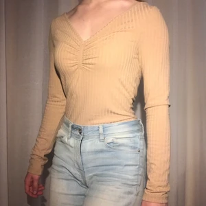 Beige ribbad topp - Superfin ribbad topp från NA-KD. Använd ett fåtal gånger. Storlek XS men sitter som S, säljer då den är lite för stor för mig. Frakt tillkommer. Jag garanterar en snabb och pålitlig affär! Sampackar gärna om du köper något mer🥰