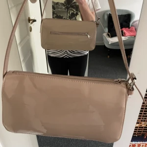 Axelväska - Den perfekta axelväska från HM! Den har ett fack på baksidan, bandens längd går att ändra och den är beige. Jättefin, men används tyvärr inte. Den är väldigt rymlig också. 