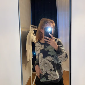 Topp med blommor - Mörkblå sweatshirt med stora blommor på, inte så tjockt material men heller inte tunt, mörklblå mudd vid ärmarna och nedtill. Strl M men passar även på S och L beroende på hur man vill att den ska sitta 🌸🌸