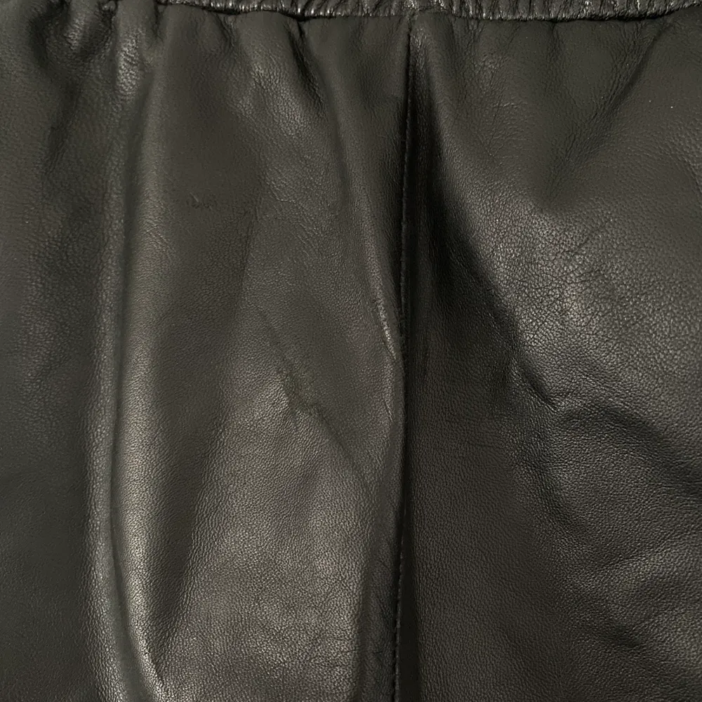 Storlek medium. 100% leather.  Ca 35 cm i midjan (stretchbart). Längsta partiet i innerbensmåttet är ca 62 cm.  Diffust märke i skinnet bak på rumpan, se bild.. Jeans & Byxor.