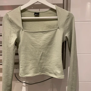 Grön topp - Grön u-ringad topp från Gina Tricot. Sitter superfint på kroppen och väldigt smickrande!!!