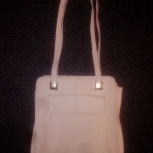Vit rymlig handväska  - Fin vit rymlig handväska med ytterfack. Sällan använda och i mycket fint begagnat skick. Ordinariepris: 239:- (fler bilder kan skickas vid intresse) billigare vid köp av fler produkter. 👜