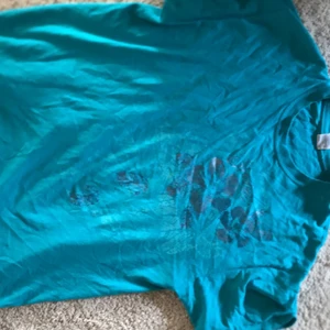 blått blommig t shirt - älskar denhär tshirten! jätte luftig och fin!! den är blommig med blåa blommor just på en plats av tröjan. 