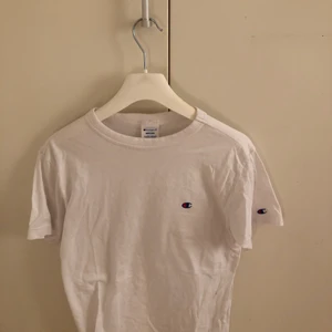 Champion t-shirt - En vit vanlig tshirt med champion loggan på bröstet.