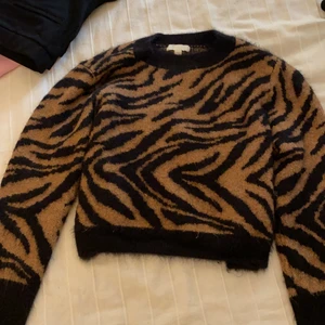 Zebra mönstrad tröja - En lite tjockare mysig stickad tröja, med zebra mönster😋 Den är som sagt lite tjockare i materialet så den passar väldigt bra när det är lite kallare.🥰 Tröjan är dock absolut inte sticksig😋den är köpt på H&M för 249kr, och är i storlek M men passar utmärkt på mig som vanligtvis har XS/S, den blir då lite oversized vilket är super gosigt☺️ i kanterna är den ytterst lite sliten dock absolut  inget man tänker på🥰 därav priset☺️✌🏼