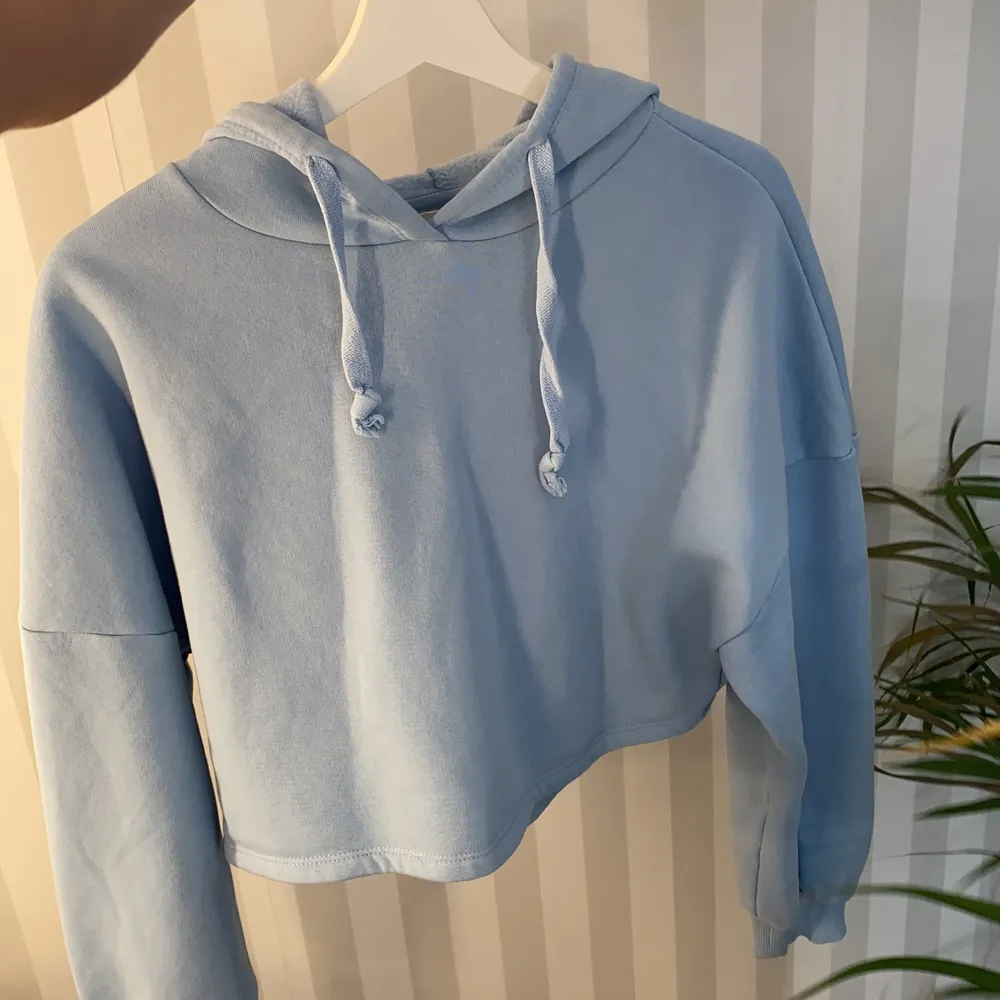 Blå croppad hoodie i storlek XS från Gina Tricot. Aldrig använt, endast hängt i min garderob. Jättefint skick. Kan fraktas. Hoodies.