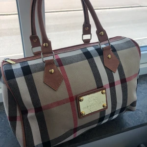 Burberry väska - En jättefin väska,säljer den för har ingen användning till den!Lite repor på den i de gulda i mitten -50