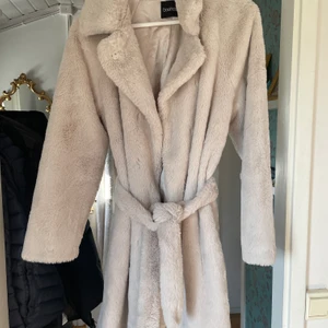 Kappa  - Jätte fin beige ”päls” kappa från boohoo. Stl 36. Ett litet hål inuti kappas (se bild 4). Annars hel och ren.