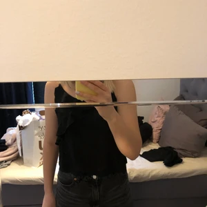 Blus - Svart blus med volanger 