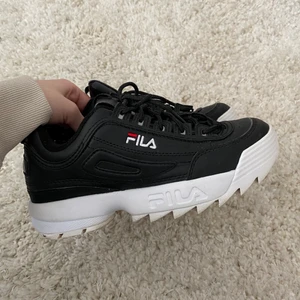 Fila disruptur low wmn sneakers  - Snygga svarta fila disruptur low sneakers i storlek 39. Säljer dessa då jag tycker att de är försmå för mig. Har använt de sparsamt och är o fint skick. Ända spår av användning är på undersidan av skon och insidan av skon. Kan självklart skicka bild på det om de önskas! Skicka privat vid intresse eller för fler bilder!