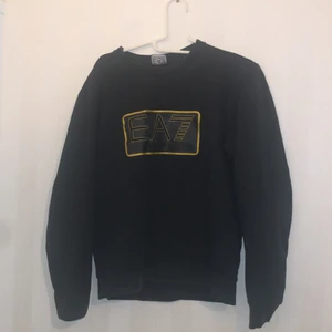 EA7 tröja - En Emporia Armani tröja med guldiga märke. I storleken M. Köpt för 1400 för 1.5 år sen. Suveränt skick inga hål ingenting endast svankades är sliten, men den sitter innanför tröjan. Märket i toppskick