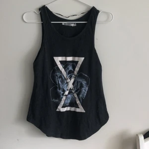 Linne med tryck - Mörkgrått linne med vit/blått tryck på framsidan. Använt skick.