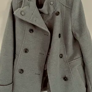 En grå kappa från HM i storlek 34, använd ett få tal gånger, i väldigt bra skick Ny pris 499, mitt pris 200kr