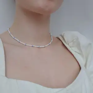 Egengjort halsband med vita glaspärlor och större blåvita randiga glaspärlor.🦋 Bestäm färg och längd. Frakt 12 kr. KOLLA IN PROFIL FÖR FLER SAKER😊