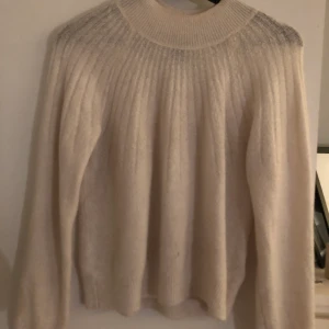 Vit stickad Tröja - En vit stickad tröja men instickande ränder. En fin markerad krage med skönt material. Tröjan är i storlek XS men passar mig med storlek S. Köpt från Lindex och använd några gånger.