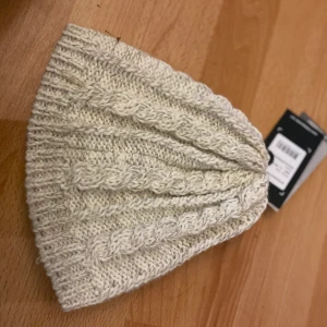 Reflexmössa  - Fin mössa, reflex när man lyser på den. Kan skicka rek för 66, annars postar jag, tror det blir 24:- men kan kolla upp vid intresse. Helt oanvänd, lappen kvar 