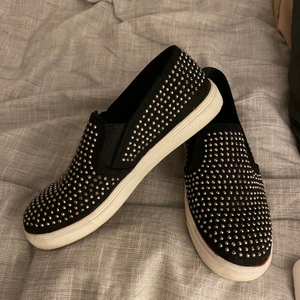 Slip ons - Svarta slip ons med paljetter. Jättefina men är försmå för mig. De är i bra skick, men smutsiga under såklart. Storlek 6, skulle uppskatta till 38 ksk🤍köpte står för frakt 