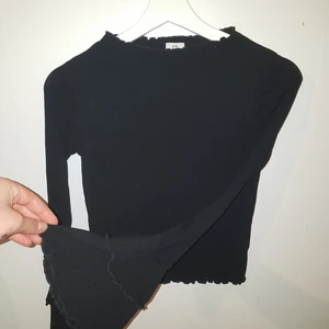 Lindex bootcat tröja - En snygg svart bootcut tröja från Lindex i sstorlek 152/11/12 år enligt Lindex. Tröjan har små volanger typ i slutet av armarna, kragen och tröjslutet. I ändarna av ärmarna är det som bootcut byxor, dom är vida utåtgående. Köparen står för frakten. 