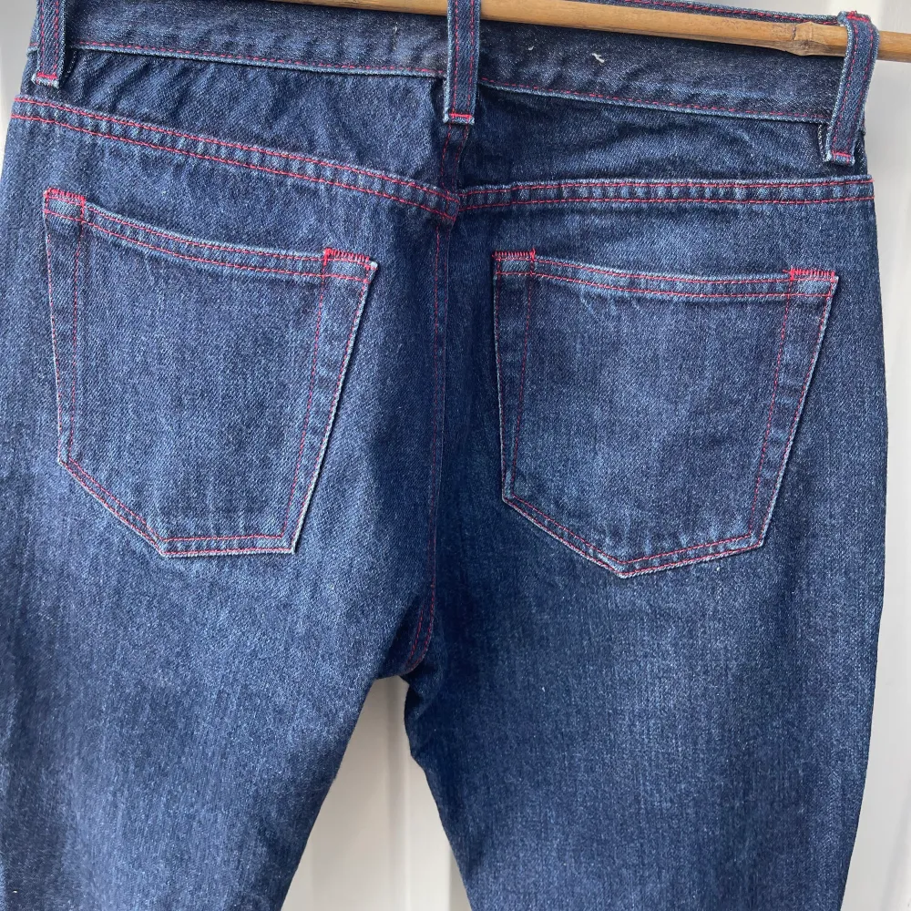 Mörkblå jeans med röda sömmar, från acne studios Storlek 28/32. Innerbenslängd: 77 cm. Midjemått: 34 cm rakt över. . Jeans & Byxor.