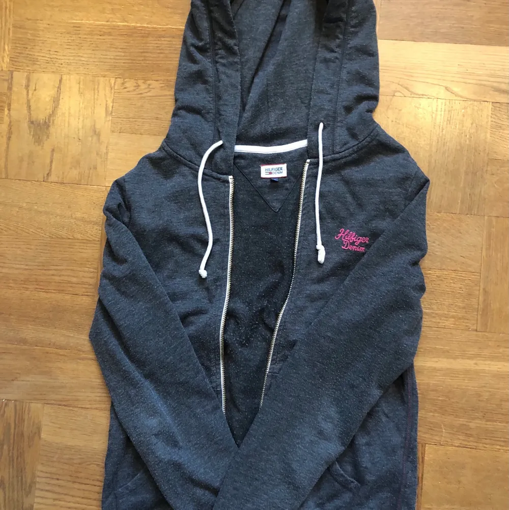 Säljer en jättefin mörkgrö zip hoodie från Tommy Hilfiger. Den är använd och lite sliten därav priset. Köparen står för frakten och betalning sker via swish.💞. Hoodies.