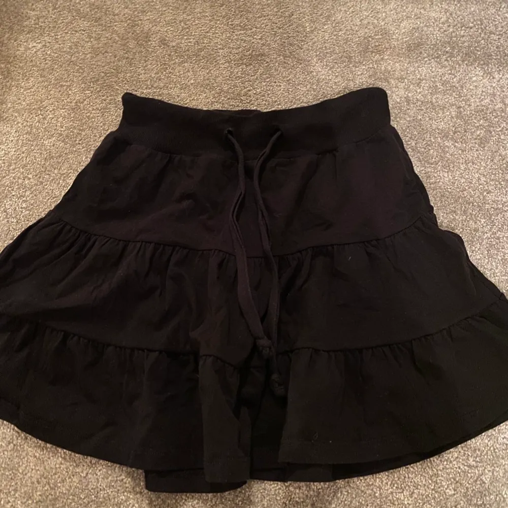 Säljer en svart supertrendig volang kjol från JC. Kjolar.