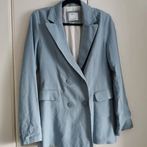 Blå kavaj från Bershka - Ljusblå kavaj med axelvaddar från Bershka. Storlek M. 