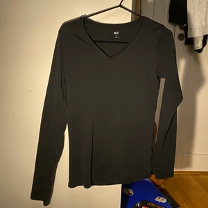 Svart Uniqlo långärmad tröja  - Svart, tight, v-ringad & långärmad tshirt från Uniqlo. Storlek M. Bra kvalitet, knappt använd! Passar bra att ha som den är eller ha en tshirt över:-) Köparen betalar för frakt.